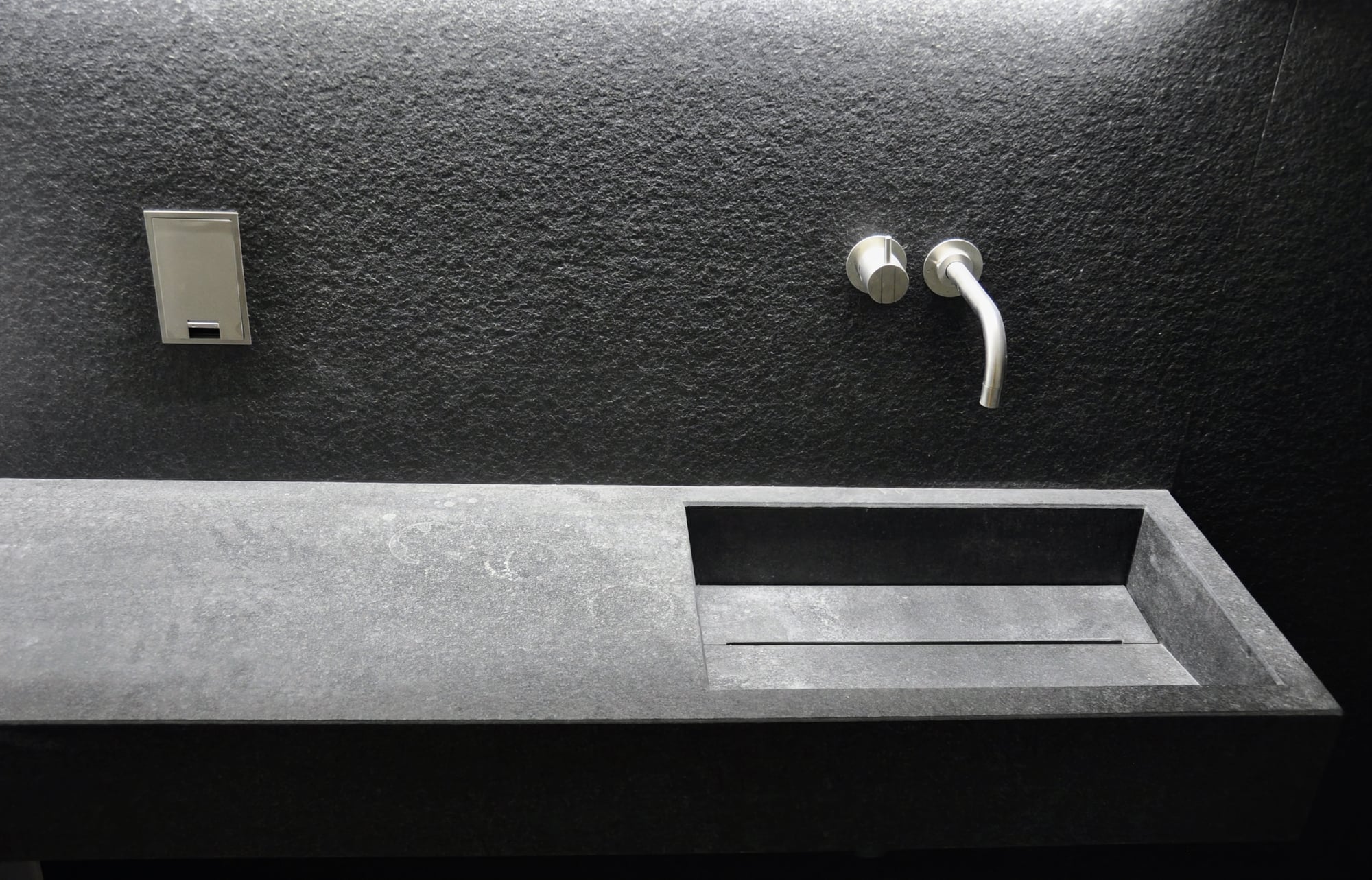 Particolare di rivestimento bagno a contrasto con piana lavabo